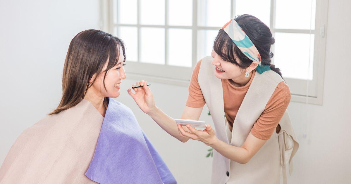 カラーアナリストが女性にメイクをしている